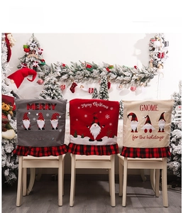 Detail of Christmas chair covers with gnome embroidery and red black plaid ruffle trim