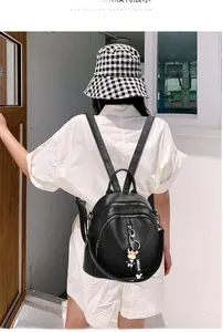 Detail view of the black leather backpack's textured surface and cute cow charm