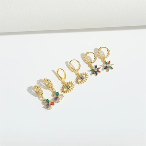 Three pairs of trendy gold earrings featuring evil eye, flowers and colorful crystals
