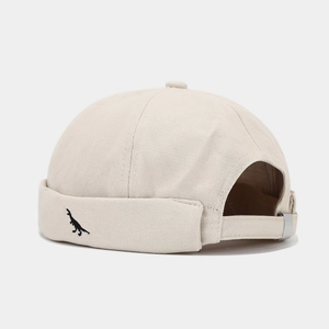 Detail of adjustable strap and small dinosaur embroidery on beige cotton miki hat