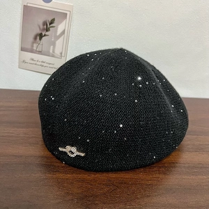 Chic black knitted newsboy cap with silver sequins and a sparkling rhinestone knot decoration