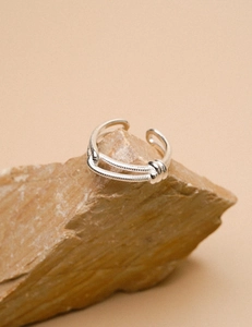 Detailed view of silver knot ring with snake chain texture on natural stone