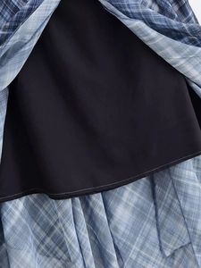 Dettaglio del tessuto in chiffon a quadri blu con fodera nera e cuciture sull'orlo