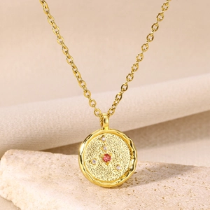 Macro detail of 18K gold constellation coin necklace with red and white zircons