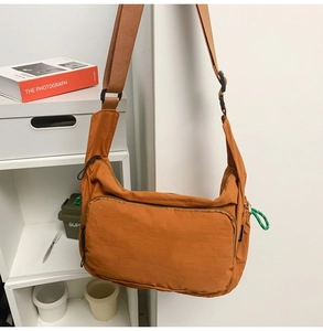 Close-up of caramel nylon messenger bag showing water-resistant texture and zipper detail