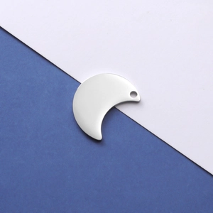Macro view of a polished silver crescent moon stainless steel pendant with a single hole