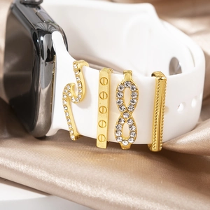 Detail of four golden rhinestones charms including snake shape for silicone watch bands