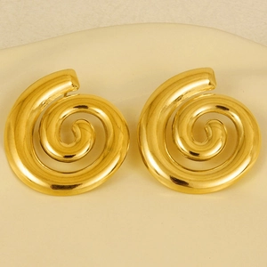 Detailed view of golden 304 stainless steel spiral shell earrings on a ceramic dish