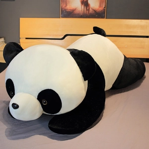 Vue détaillée de la peluche géante de panda noir et blanc sur un lit en bois naturel