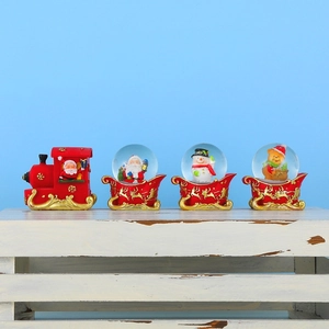 Christmas crystal ball set with resin train and sleigh figurines on a blue background