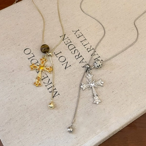 Tiger eye stone cross pendant Y-necklace with crystal beads on a vintage book background