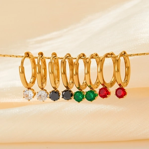 Golden stainless steel hoop earrings with colorful zircon drops on silk background