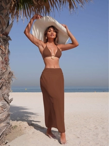 Three-piece brown bikini set with metallic ring detail and matching mesh maxi beach skirt