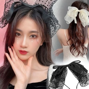 Close-up of oversized French polka dot mesh bow hair clip in black and cream colors