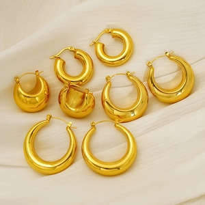 Polished 18K gold plated hollow hoop earrings in various sizes on white fabric