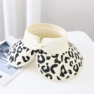 Close-up of leopard print pattern and bow detail on an open-top straw sun hat