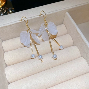 Gros plan détaillé de boucles d'oreilles pétales en acrylique blanc avec perles