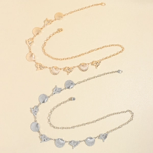Detailed close-up of vintage gold and silver beach waist chains with seashell charms