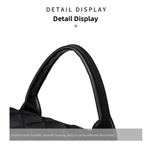 Detail view of the soft quilted pattern and comfortable rounded handle of the black backpack