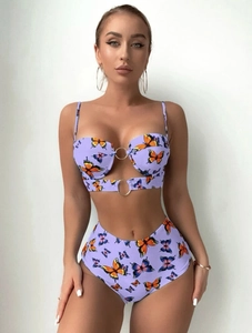 Détail du maillot avec connecteur à anneau métallique et motif de papillon violet vif