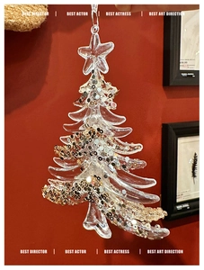 Macro detail of transparent acrylic Christmas tree ornament with gold and silver sequins