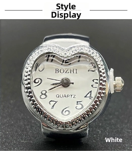 Detail of silver heart-shaped ring watch with quartz movement and crystal bezel