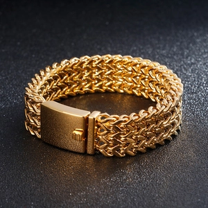 Macro detail of men's chunky gold woven chain bracelet with polished box clasp