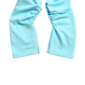 Détail du tissu élastique bleu clair avec design froncé et ourlet à double couture