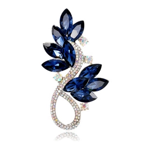 Macro detail of leaf-shaped blue crystal brooch with shimmering rhinestones and silver base