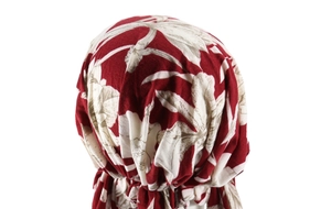 Detail of red floral pre-tied turban showing elastic back fit and pleated texture