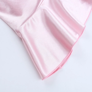 Détail du satin rose montrant l'ourlet à volants élégant et la couture de précision