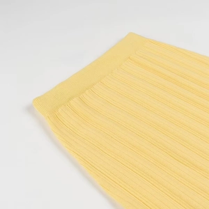 Gros plan sur le tissu en maille jaune montrant la texture côtelée et la qualité du textile