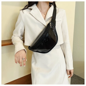 Detail of a minimalist black glossy PVC waist bag with adjustable strap on white suit