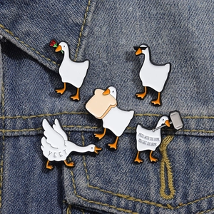 Detail of white goose enamel pins on denim, featuring funny internet meme text and unique poses