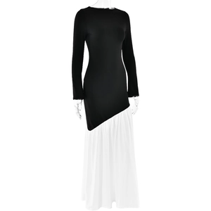 Detail of slim-fit patchwork maxi dress featuring a black bodice and white pleated skirt