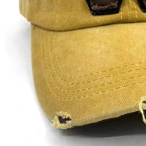 Detailaufnahme der gewaschenen Baumwollkappe mit Distressed-Effekt und Dreifachnaht
