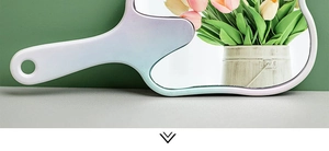 Detail of the gradient plastic handle on a tooth shaped hand mirror with a hanging hole