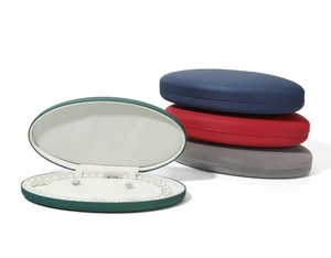 Oval velvet jewelry box stack with green box open showing pearl necklace and earrings