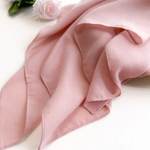 Close-up of soft pink cotton linen fabric texture with delicate stitched edges
