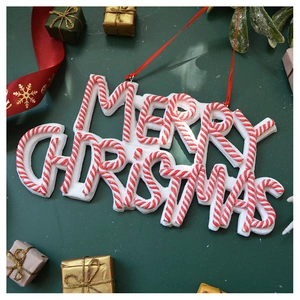 Macro shot of Merry Christmas hanging sign with red and white candy cane textures