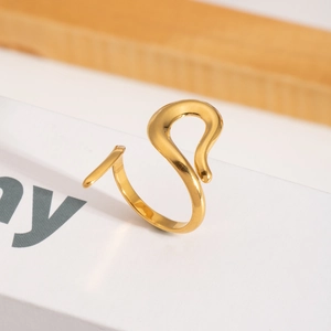 Detail shot of the polished 18K gold plated fluid snake ring on a minimalist display