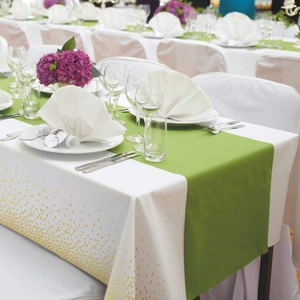 Detail of white tablecloth with gold polka dots and a green table runner for events