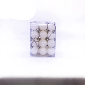 Close-up of 24 white Christmas balls with shiny, matte, and glitter finishes in a clear box