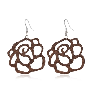 Detailed view of hollowed-out wooden rose earrings in brown with subtle reflections