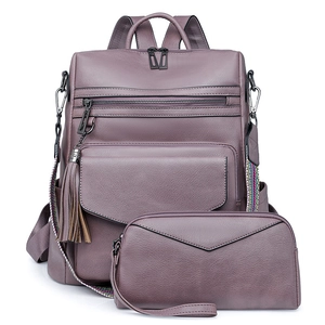 Detail of purple leather backpack with tassel charm and colorful woven shoulder strap