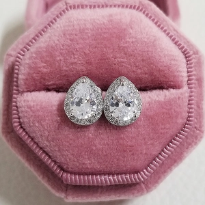 Macro view of pear-cut cubic zirconia stud earrings in a pink velvet jewelry box