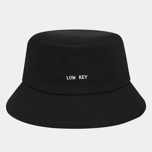 Classic black cotton bucket hat with LOW KEY white embroidery on a light grey background