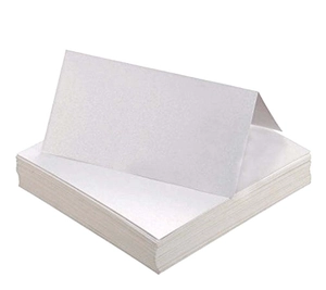 Macro shot of white foldable paper place cards stacked for wedding table seating settings