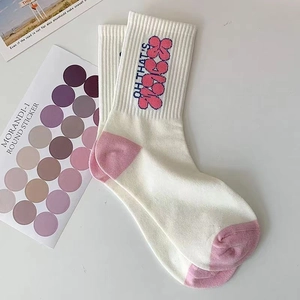 Dettaglio calzini in cotone bianco con talloni rosa e scritte stampate 'OH THAT'S'