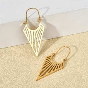 Vue détaillée des boucles d'oreilles géométriques dorées ajourées sur fond texturé